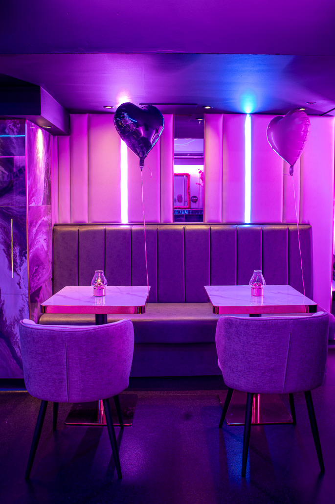 Booth seating with heart balloons and candlelit tables