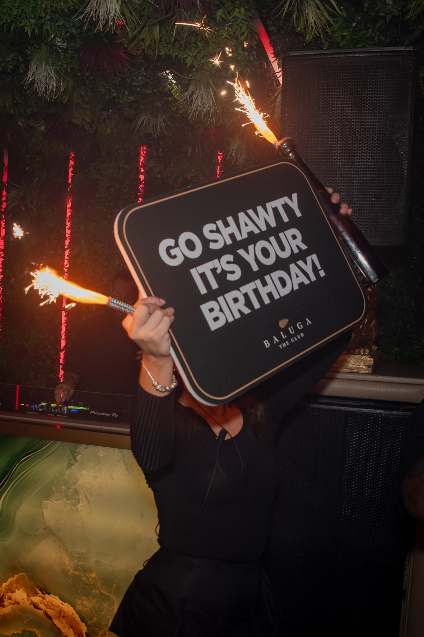 A Go Shawty It's Your Birthday sign held up with a sparkler