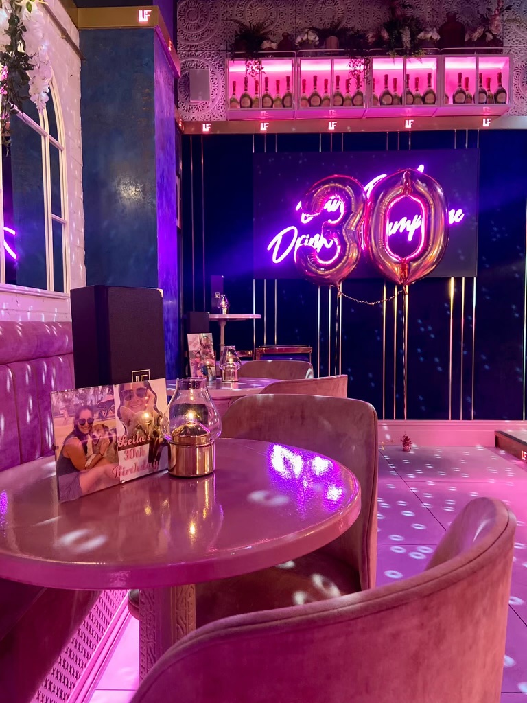 Le Fleur set for a 30th birthday with a pink neon sign and disco floor
